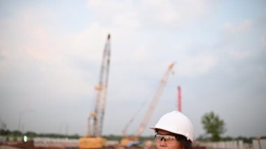 Civil engineer working at a construction site, The company manager supervises the road construction.