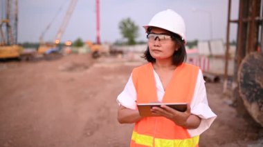 Civil engineer working at a construction site, The company manager supervises the road construction.