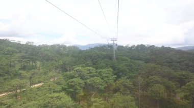 Dağlardaki yeşil ormanın üzerinden geçen kablo araba.