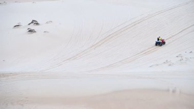 Sürücü aracıyla kumlu çöl manzarası