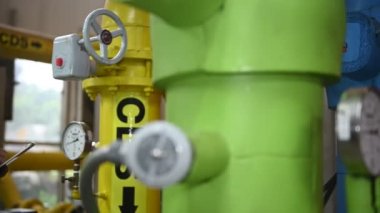 Kazan dairesinde çalışan gözlüklü Asyalı mühendis, ısıtma sistemi ekipmanlarının teknik verilerini kontrol ediyor, Taylandlılar