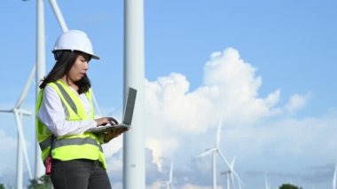 Tayland 'daki dağda rüzgar türbini çiftliği elektrik jeneratörü istasyonunda çalışan ve raporu tutan kadın mühendis.