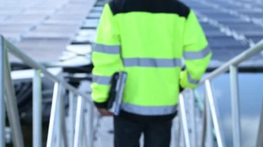 Yüzen güneş enerjisi santralinde çalışan Asyalı mühendis, yenilenebilir enerji, teknisyen ve yatırımcı güneş panelleri güneş enerjisi kurulumundaki panelleri kontrol ediyor