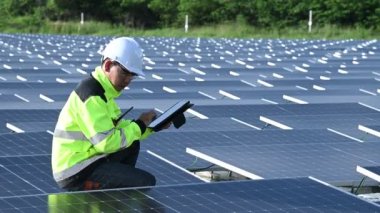 Yüzen güneş enerjisi santralinde çalışan Asyalı mühendis, yenilenebilir enerji, teknisyen ve yatırımcı güneş panelleri güneş enerjisi kurulumundaki panelleri kontrol ediyor
