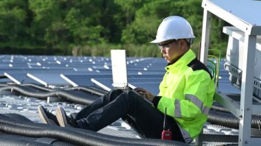 Yüzen güneş enerjisi santralinde çalışan Asyalı mühendis, yenilenebilir enerji, teknisyen ve yatırımcı güneş panelleri güneş enerjisi kurulumundaki panelleri kontrol ediyor