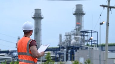 Petrol ve gaz rafinerisi fabrikasında çalışan Asyalı petrokimya mühendisi elektrik santrali enerji imalatında çalışan insan işçi mühendisi.