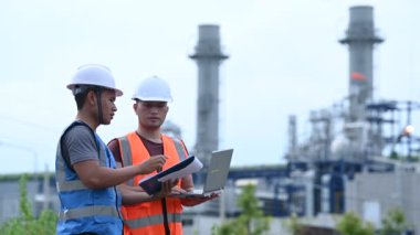 Elektrik santralinde çalışan iki mühendis, birlikte mutlu bir şekilde çalışıyorlar, sorunu çözümlemede birbirlerine yardım ediyorlar, kalkınma yönergeleri hakkında danışmanlık yapıyorlar.