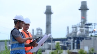 Elektrik santralinde çalışan iki mühendis, birlikte mutlu bir şekilde çalışıyorlar, sorunu çözümlemede birbirlerine yardım ediyorlar, kalkınma yönergeleri hakkında danışmanlık yapıyorlar.