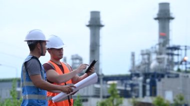 Elektrik santralinde çalışan iki mühendis, birlikte mutlu bir şekilde çalışıyorlar, sorunu çözümlemede birbirlerine yardım ediyorlar, kalkınma yönergeleri hakkında danışmanlık yapıyorlar.