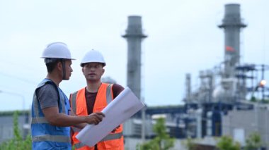 Elektrik santralinde çalışan iki mühendis, birlikte mutlu bir şekilde çalışıyorlar, sorunu çözümlemede birbirlerine yardım ediyorlar, kalkınma yönergeleri hakkında danışmanlık yapıyorlar.