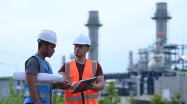 Elektrik santralinde çalışan iki mühendis, birlikte mutlu bir şekilde çalışıyorlar, sorunu çözümlemede birbirlerine yardım ediyorlar, kalkınma yönergeleri hakkında danışmanlık yapıyorlar.
