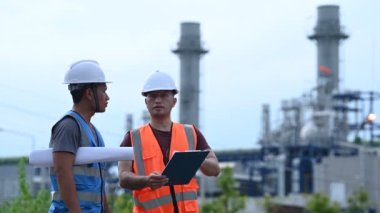 Elektrik santralinde çalışan iki mühendis, birlikte mutlu bir şekilde çalışıyorlar, sorunu çözümlemede birbirlerine yardım ediyorlar, kalkınma yönergeleri hakkında danışmanlık yapıyorlar.
