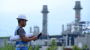 Petrol ve gaz rafinerisi fabrikasında çalışan Asyalı petrokimya mühendisi elektrik santrali enerji imalatında çalışan insan işçi mühendisi.