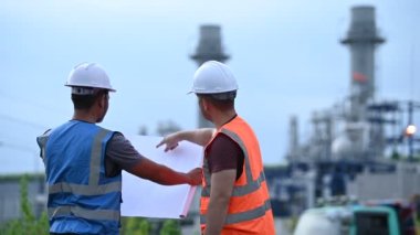 Elektrik santralinde çalışan iki mühendis, birlikte mutlu bir şekilde çalışıyorlar, sorunu çözümlemede birbirlerine yardım ediyorlar, kalkınma yönergeleri hakkında danışmanlık yapıyorlar.