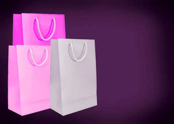 Pink paper bags on dark background. — Stock Photo, Image