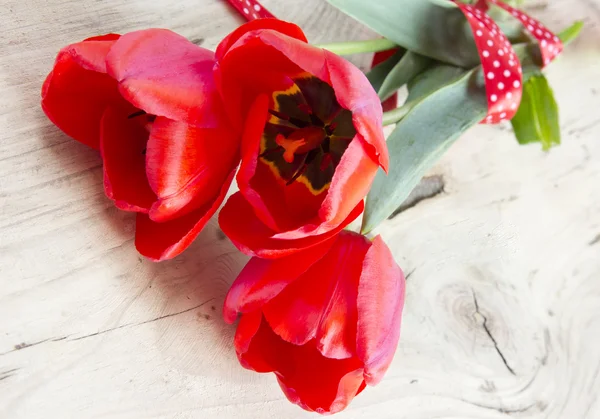 Red tulips bouquet on wooden background. — Stock Photo, Image