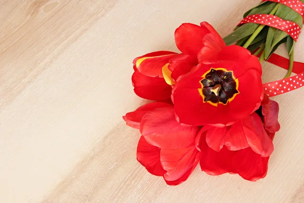 Red flowers bouquet on wooden background with space for text. — Stock Photo, Image
