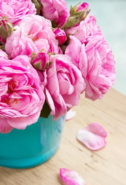 束玫瑰插在花瓶里的木桌特写. — 图库照片