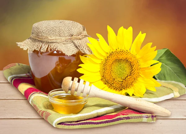 Скляна чаша меду з соняшником на дерев'яному столі . — стокове фото