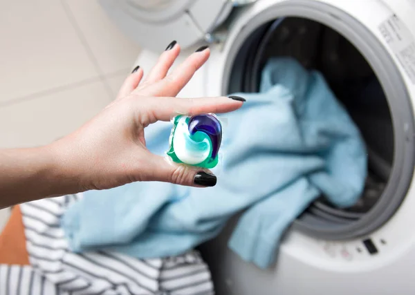 Vrouwenhand Met Gelcapsule Capsule Achtergrond Van Wasmachine Kleding Wassen Schoonmaakdoek — Stockfoto