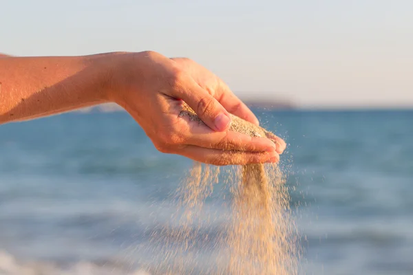 Sand flowing through hands — Stock Photo, Image