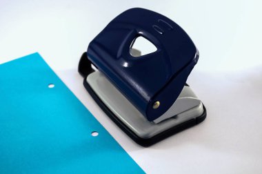 office: punch, blue paper with punch holes on a white background 