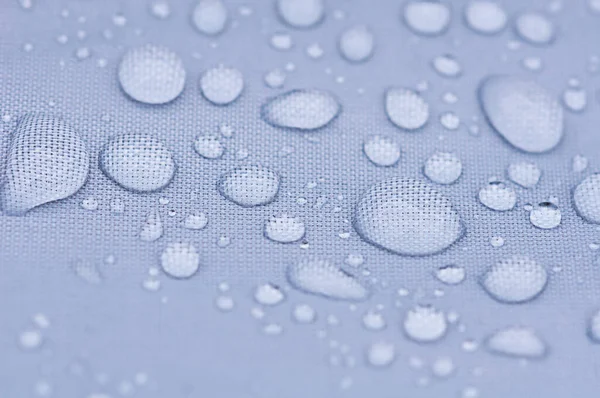 transparent big drops on a blue background close-up