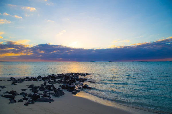 Strand mit Felsen bei Sonnenuntergang — Stockfoto