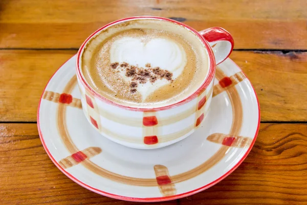 Caffè caldo con latte art a forma di herat in una tazza — Foto Stock