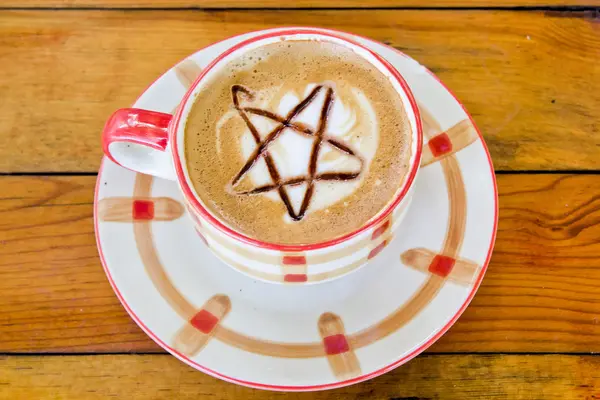 Café caliente con forma de estrella de arte latte en una taza — Foto de Stock