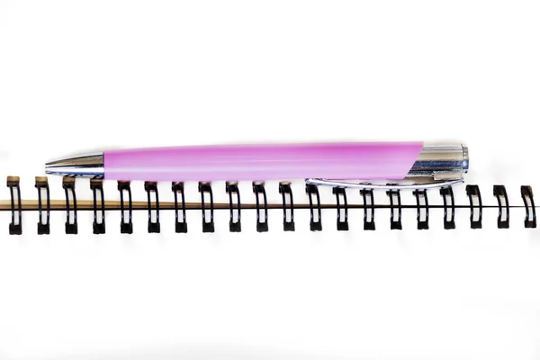 Ноутбук и розовая ручка на белом — стоковое фото