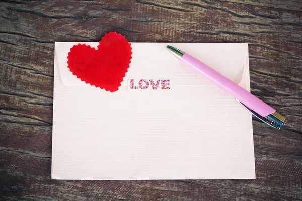 Umschlag und Kugelschreiber mit Herz. — Stockfoto
