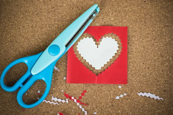 Herzförmiges Papier für die Dekoration am Valentinstag schneiden. — Stockfoto
