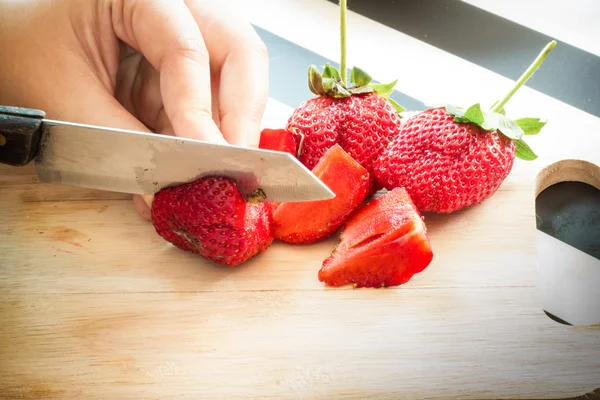 Hand chopping a fresh strawberry in kitchen — Stock Photo, Image