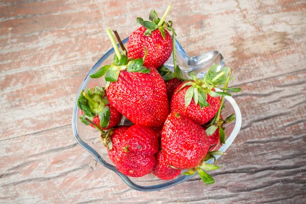 Fresh strawberries in a glass bowl on wood background — Stock Photo, Image