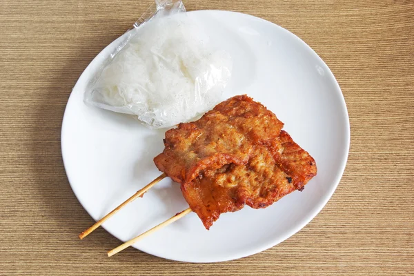 Barbacoa de cerdo a la parrilla con arroz pegajoso en un plato blanco — Foto de Stock