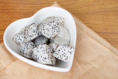 ahşap masa üzerine küp doğranmış dragon meyve.