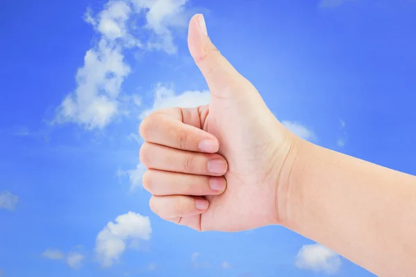 Nő kéz a hüvelykujjával felfelé a kék ég háttér — Stock Fotó