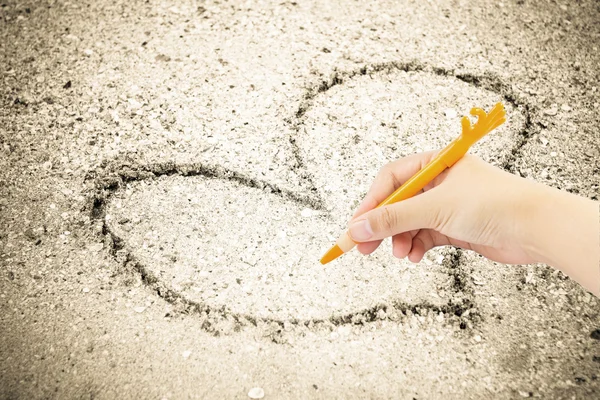 Hand skriver med penna på sand bakgrund — Stockfoto