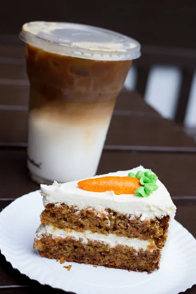 Морквяний торт і крижана кава на столі — стокове фото