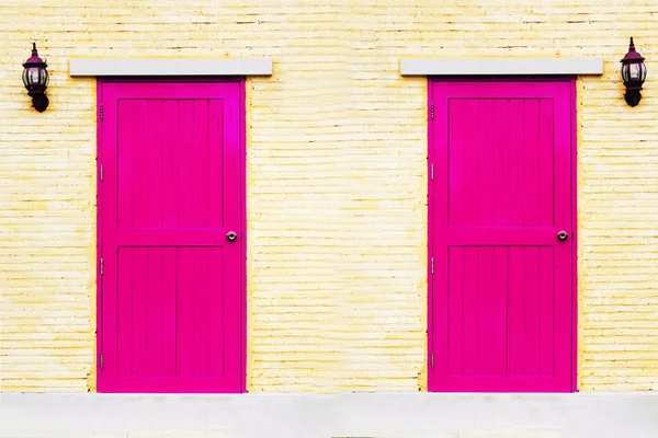 Et rosa par dører på murveggen. – stockfoto