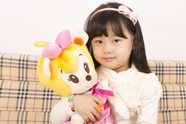 güzel küçük bir kız bir bebekle oynarken