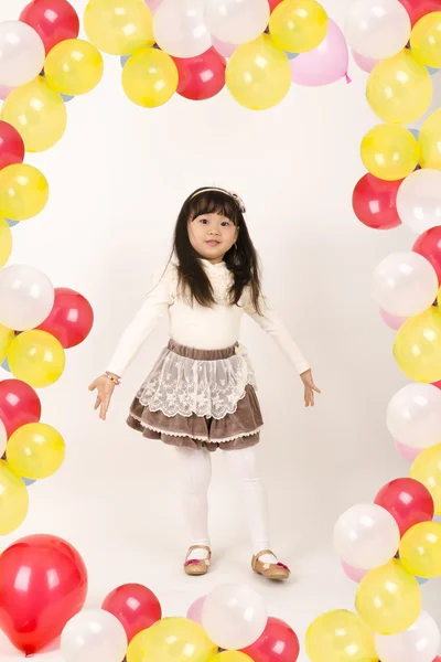 Renkli balonlar ile oynayan güzel küçük kız .
