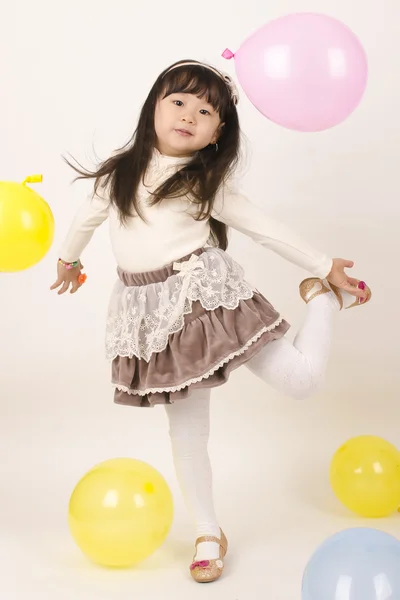 Renkli balonlar ile oynayan güzel küçük kız .