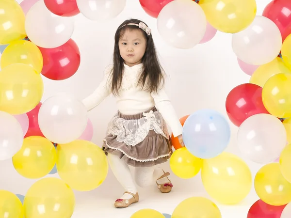 Renkli balonlar ile oynayan güzel küçük kız .