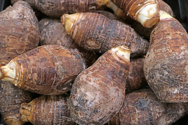 Heap of Raw Taro Roots on a Market Stall