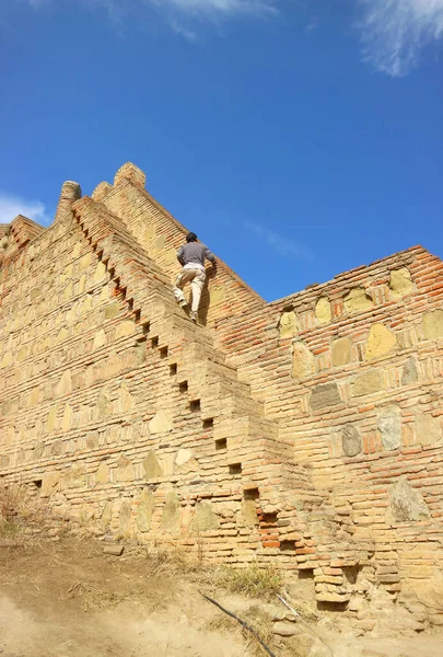 Visitor Climbing onto the Steep Steps of Wall Remains of Narikala Fortress, Old Tbilisi, Georgia