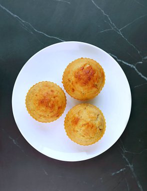 Kara mermer masa üzerinde muzlu kek tabağının en üst görüntüsü.