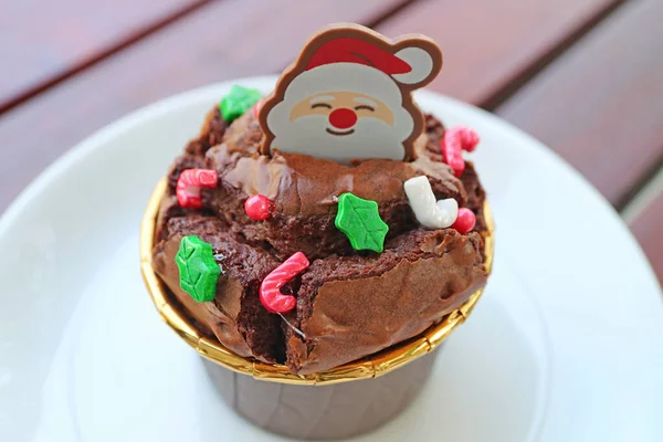 チョコレートカップケーキの上にサンタチョコとクリスマススプリンクルが乗っています — ストック写真