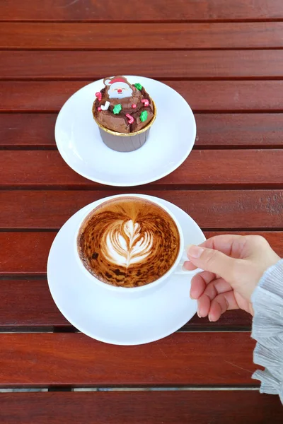 Рука Держа Чашку Горячего Кофе Капучино Тарелкой Рождественского Шоколадного Кекса — стоковое фото